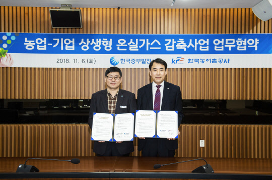 정승교 한국중부발전 발전환경처장(왼쪽)과 장중석 한국농어촌공사 농어촌연구원장이 6일 중부발전 본사에서 농업-기업 상생형 온실가스 감축 사업을 위한 업무협약을 체결한 뒤 기념촬영을 하고 있다..<중부발전 제공>